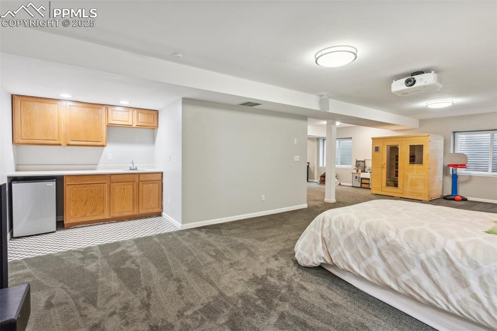 Image 25 of 37: Finished basement with a full bathroom, wet bar, and theater projector.