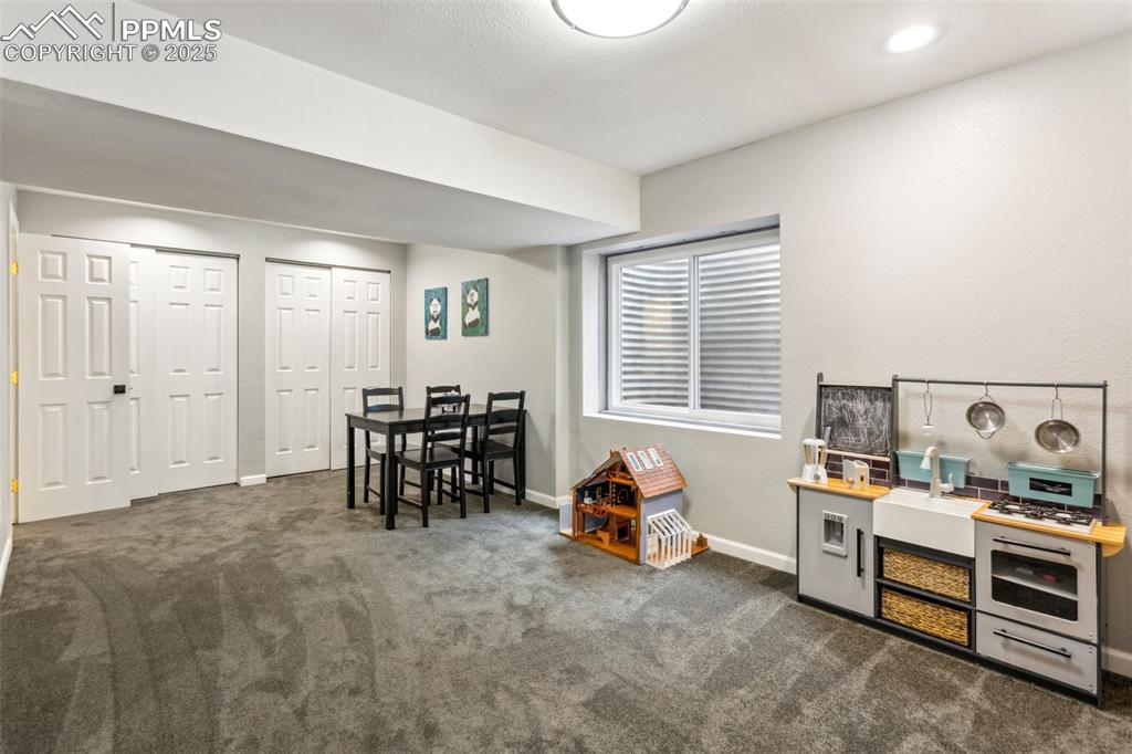 Image 26 of 37: Finished basement with a full bathroom, wet bar, and theater projector.