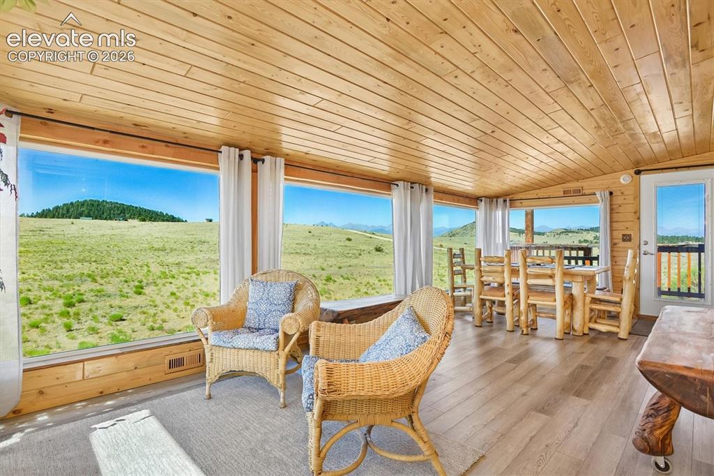 Image 11 of 29: Interior space featuring extensive panoramic windows, wood-finish flooring,