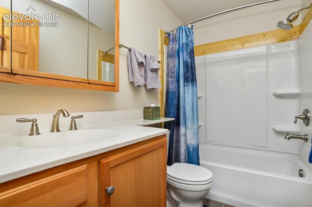 Image 14 of 29: Bathroom featuring a white integrated sink, brushed nickel faucet, and a li