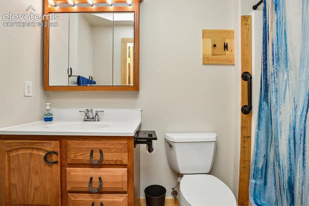 Image 22 of 29: Bathroom vanity featuring a wood-finish cabinet with horseshoe-shaped hardw