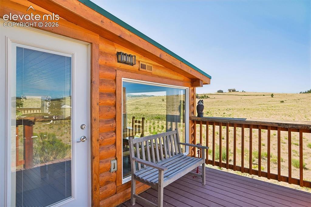 Image 23 of 29: Wood-sided exterior featuring a deck with wooden railings
