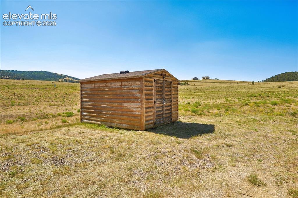 Image 27 of 29: Freestanding wood-sided shed with a sloped roof