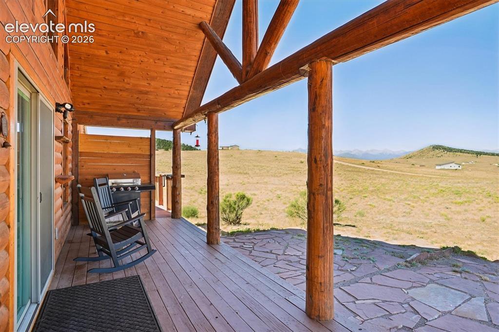 Image 3 of 29: Expansive covered patio featuring a wood-finish plank floor, wood-paneled c