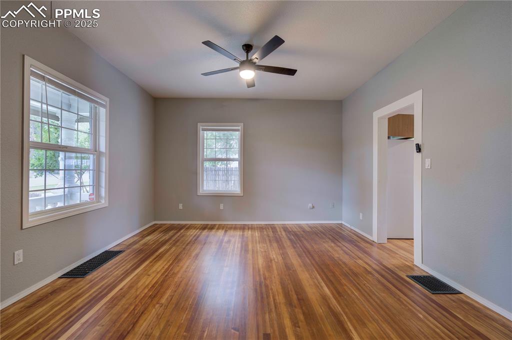 Image 14 of 19: Empty room with wood finished floors and ceiling fan