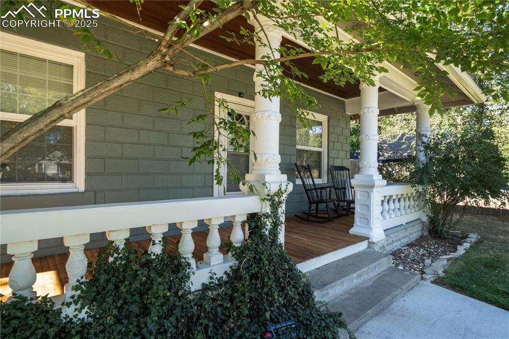 Image 4 of 19: View of side of home with covered porch and concrete block siding