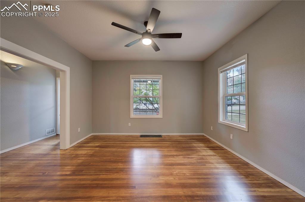 Image 8 of 19: Spare room with wood finished floors and ceiling fan