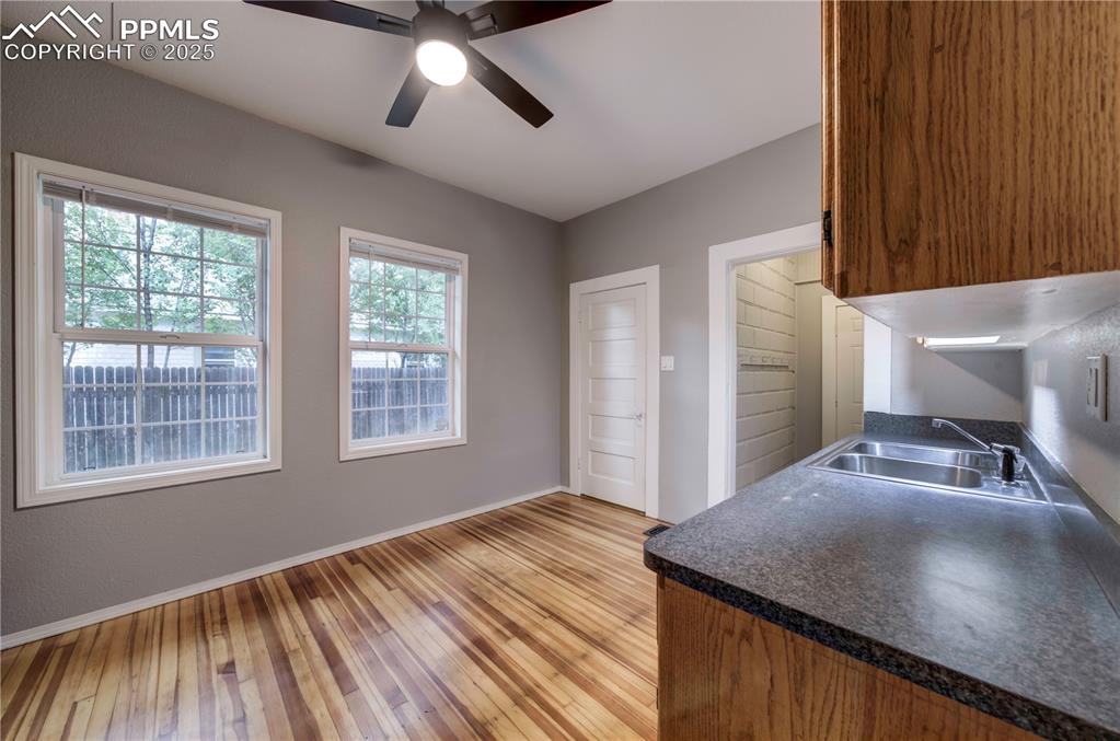 Image 9 of 19: Kitchen featuring dark countertops, light wood-type flooring, a ceiling fan