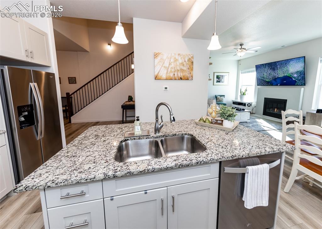 Image 11 of 49: Kitchen with white cabinetry, stainless steel appliances, a kitchen island