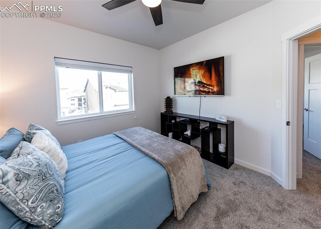 Image 35 of 49: Carpeted bedroom with ceiling fan and baseboards