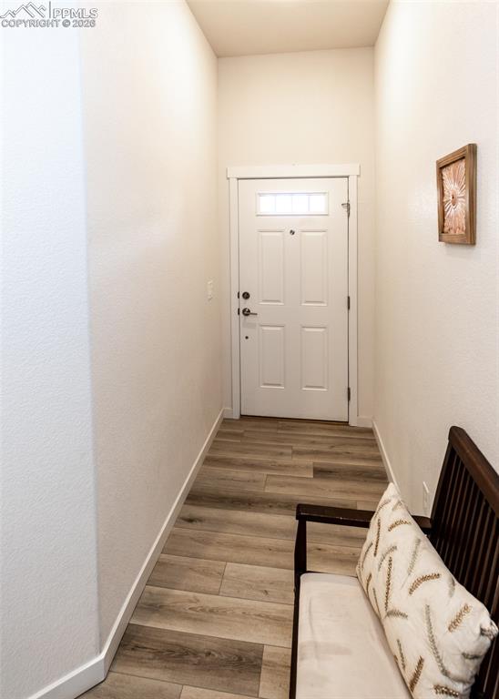 Image 4 of 49: Doorway to outside with wood finished floors and baseboards