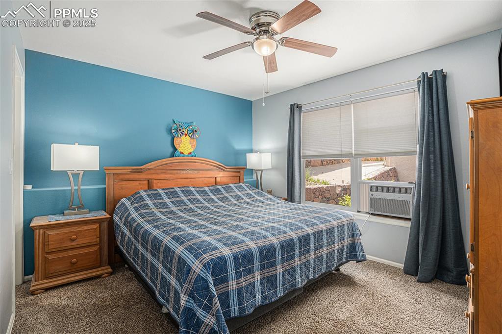 Image 12 of 22: Sunny main level bedroom with newly carpeted flooring and large window