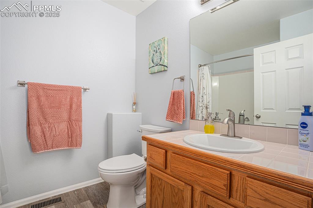 Image 13 of 22: Main level bath with vanity and tub shower combo, upgraded faucet