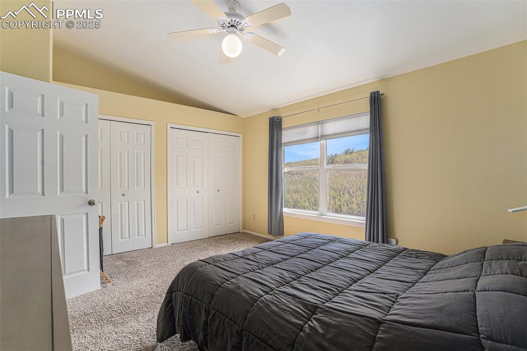 Image 16 of 22: Upper level bedroom with great closet space, vaulted ceiling, and a ceiling