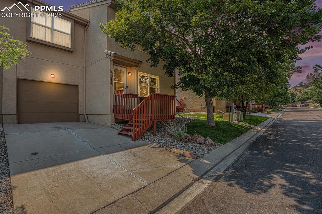 Image 2 of 22: Twilight view of front of property with stucco siding, driveway, and an att