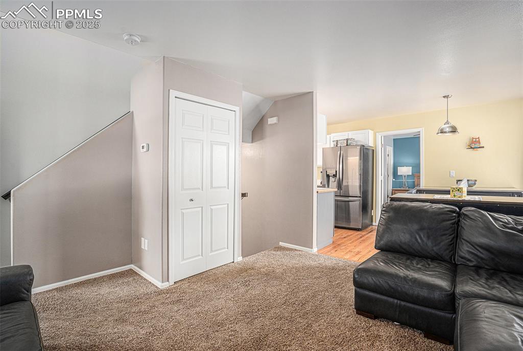 Image 6 of 22: Living room featuring with stairs down to oversized 1 car garage