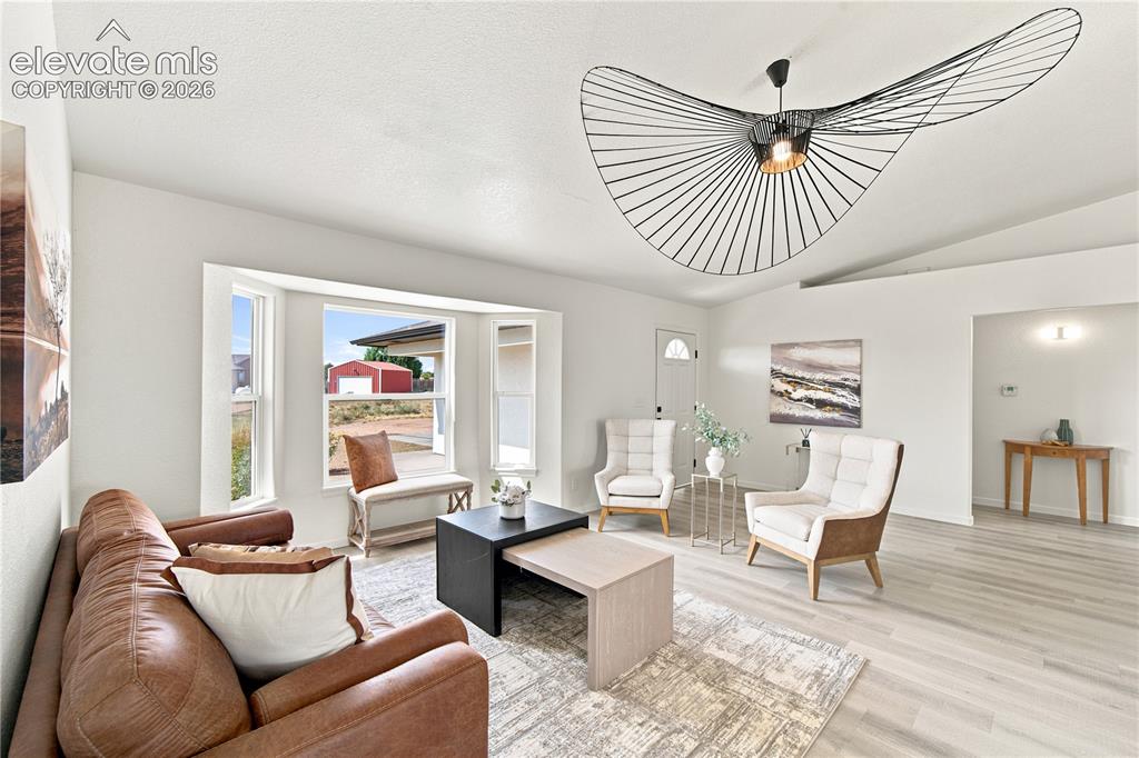 Image 10 of 40: Spacious living area featuring light wood-finish flooring, a contemporary c
