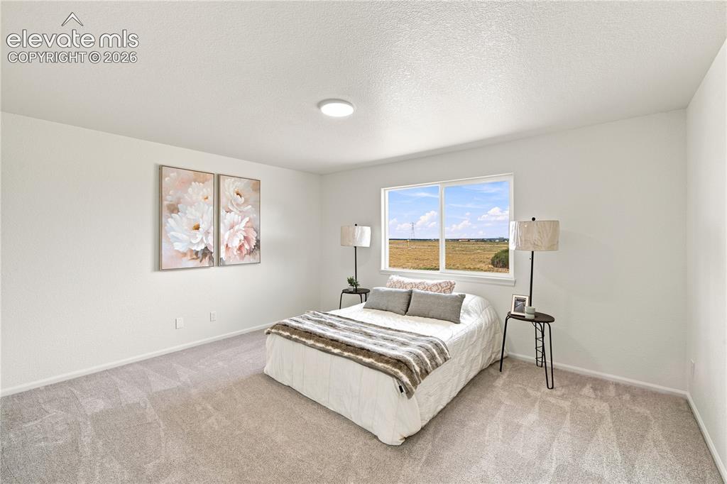 Image 13 of 40: Carpeted room featuring a large window, white walls, and a ceiling-mounted 