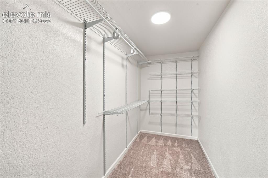 Image 17 of 40: Walk-in closet featuring wire shelving, hanging rods, recessed ceiling ligh