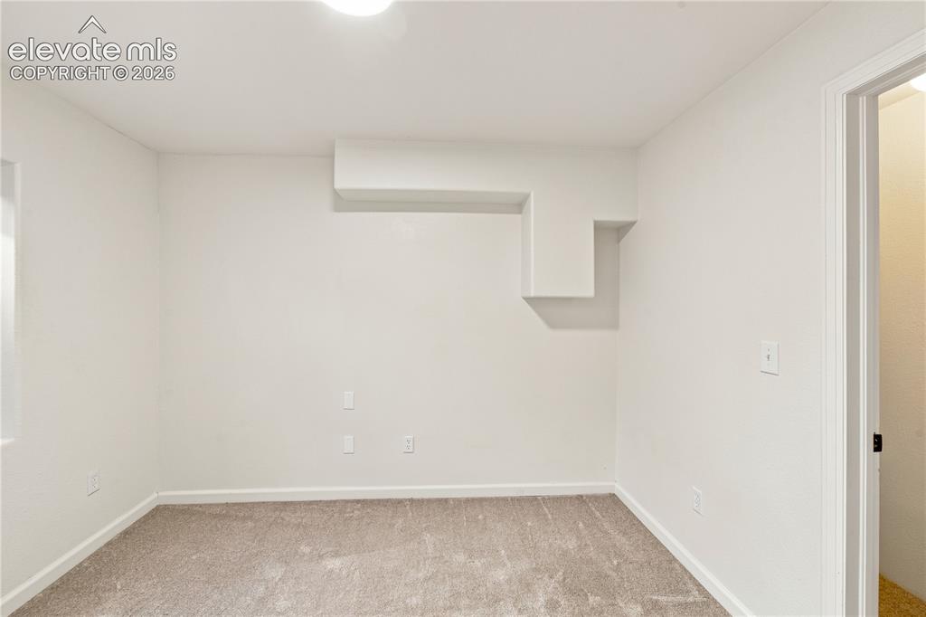 Image 27 of 40: Bright interior space featuring a light neutral color palette, plush carpet