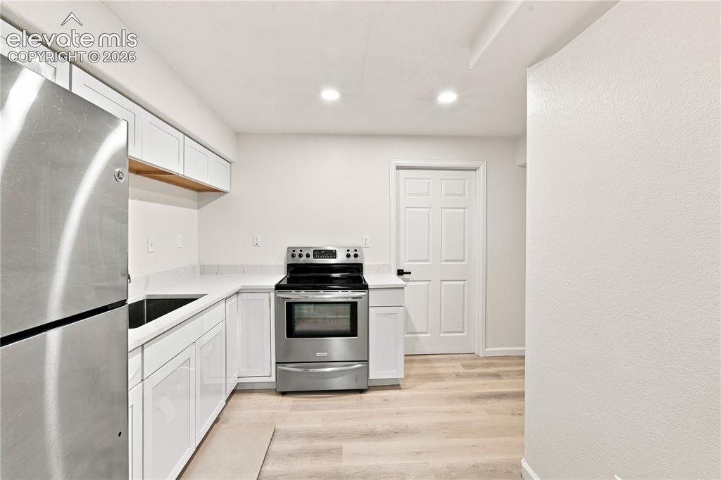 Image 29 of 40: Kitchen featuring white shaker cabinetry, stainless steel appliances, light