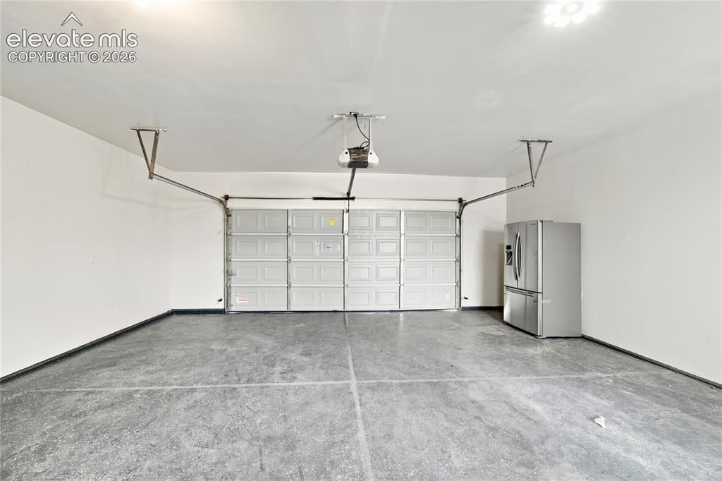 Image 35 of 40: Two-car garage featuring a sectional overhead door with an automatic opener