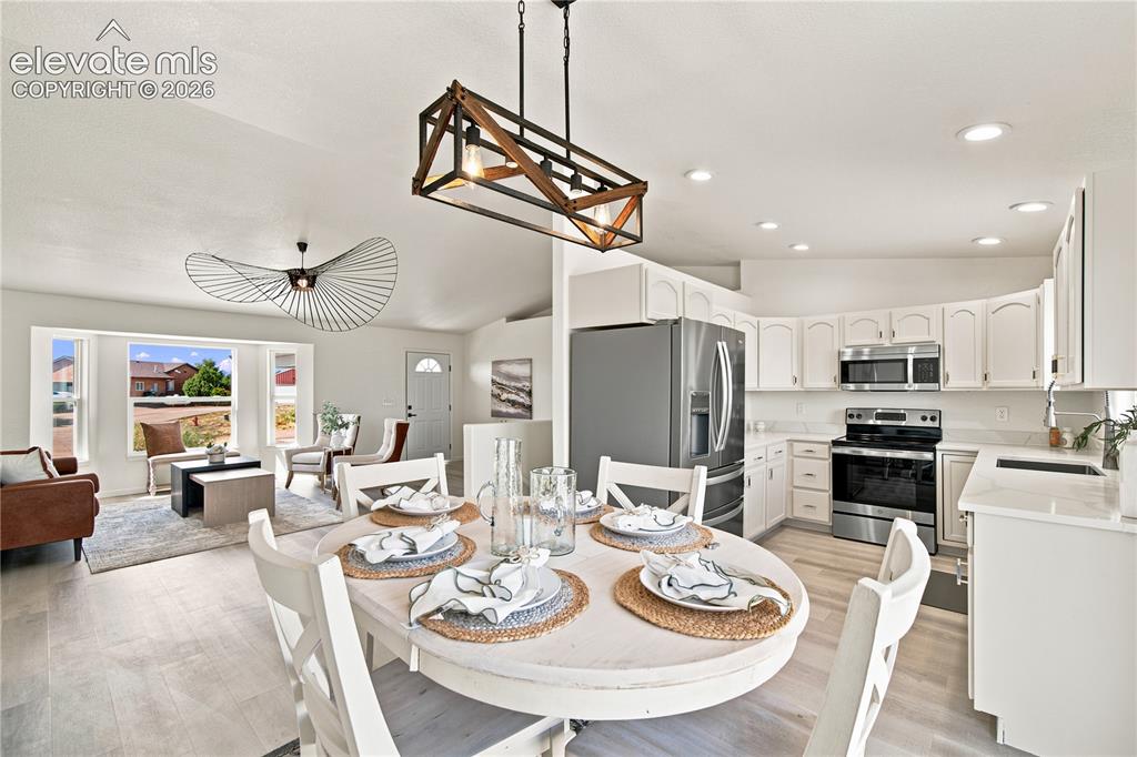 Image 7 of 40: Open concept living space featuring a dining area, kitchen, and living room