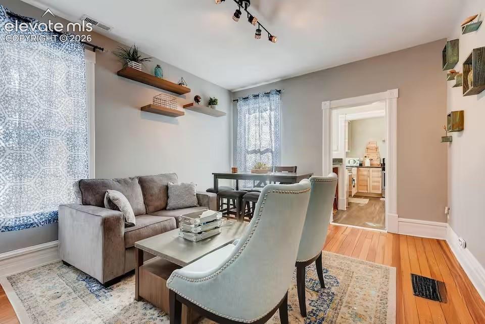 Image 10 of 27: Original wood floors and victorian architecture blend well with modern touc