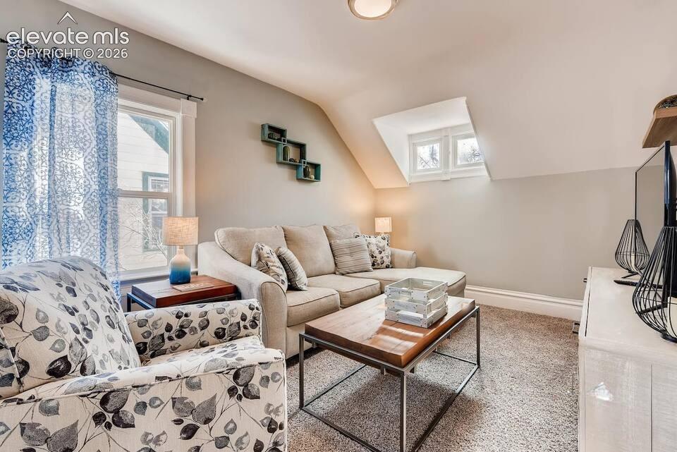 Image 17 of 27: Second floor living room or bedroom with fun slanted ceiling and dormer win