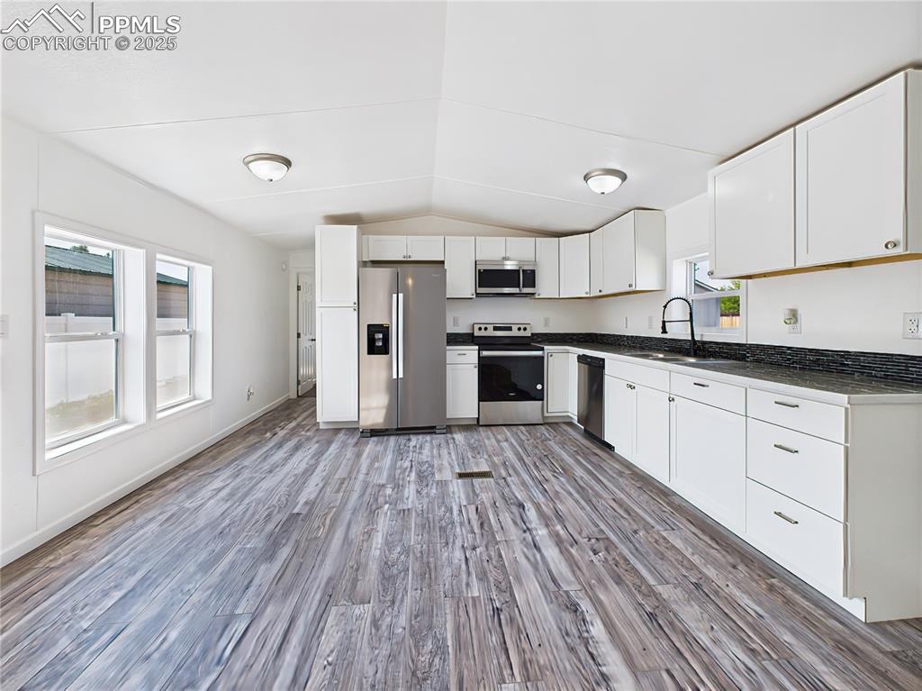 Image 13 of 49: Kitchen & Dining Space – Sunlit kitchen with room for dining, featuring upd