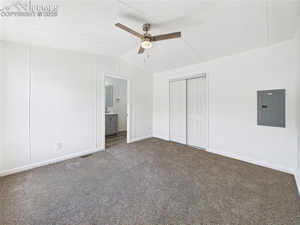 Image 18 of 49: Primary Bedroom – Generously sized with plush carpeting, a ceiling fan, and