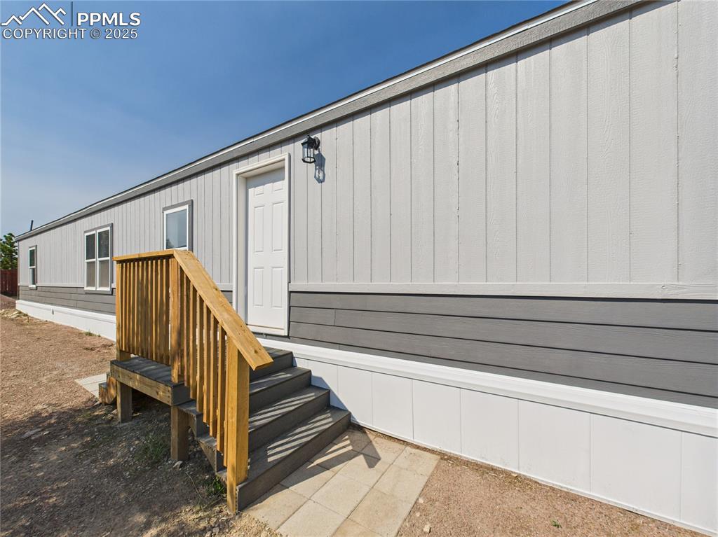 Image 2 of 49: Front Entrance – features a newly built wooden staircase and landing, with