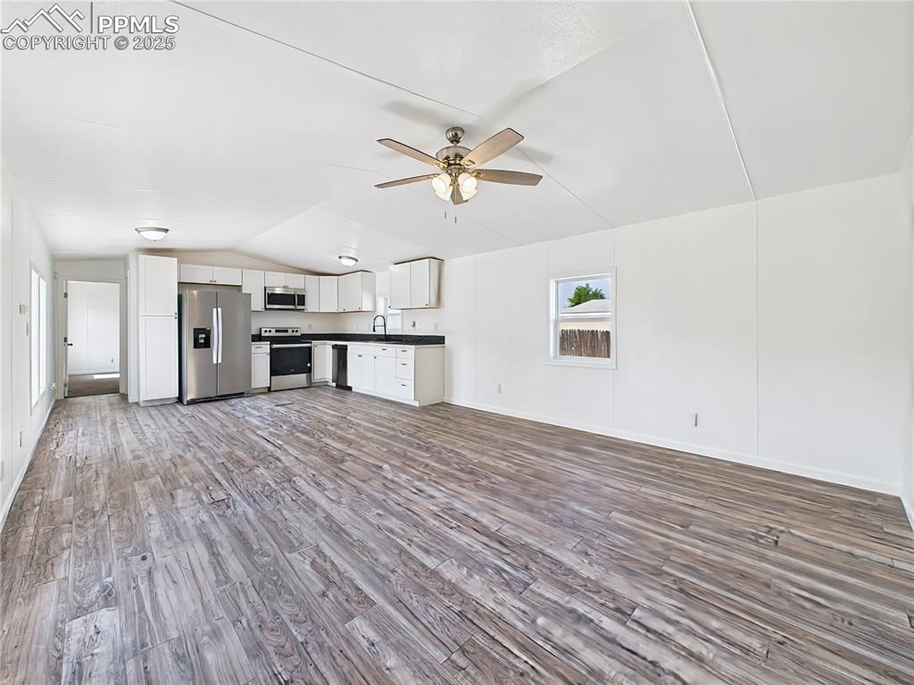 Image 3 of 49: Open Living Area – Bright and spacious open-concept layout with wood-look v