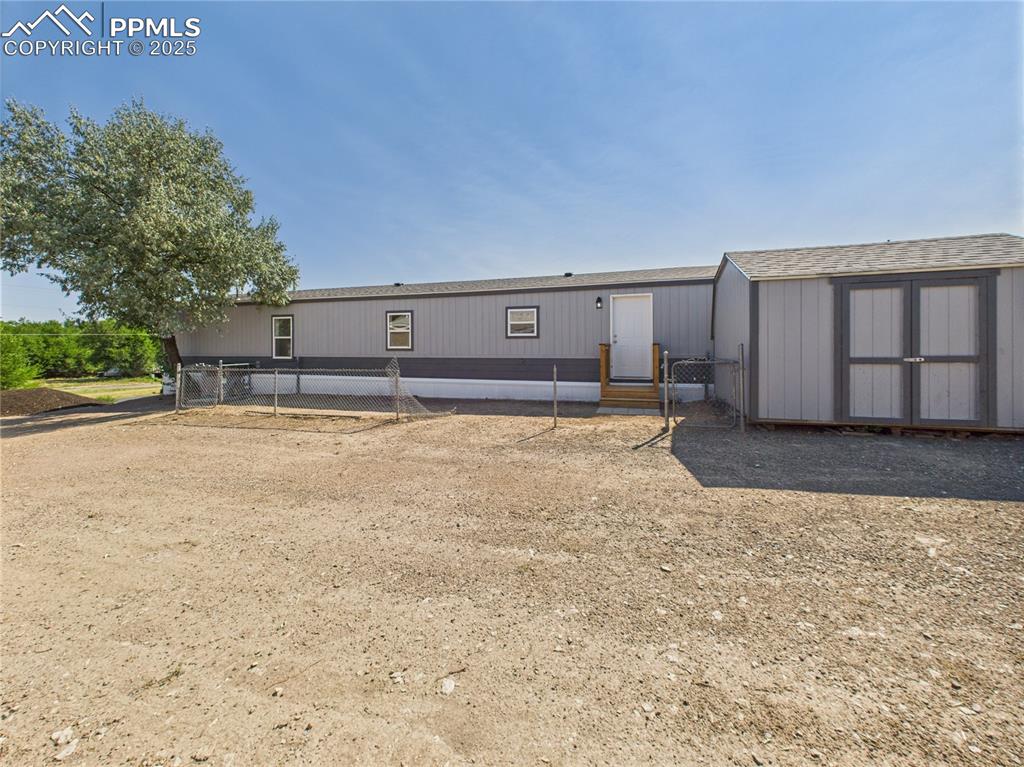 Image 43 of 49: Back of Home with Shed – Rear view includes fenced area and matching storag