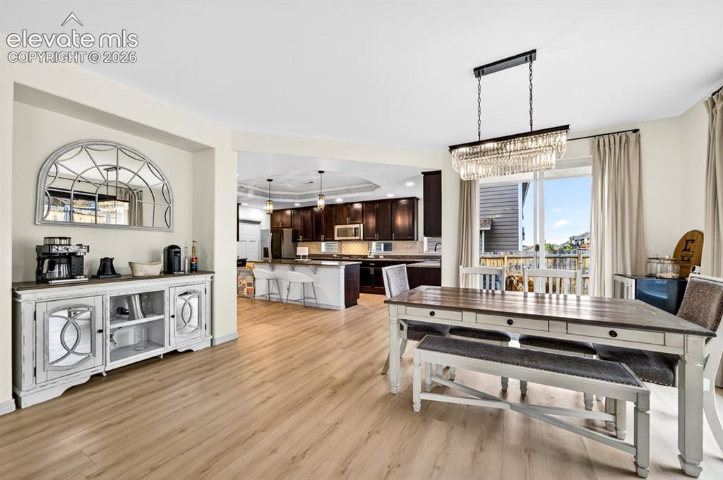 Image 21 of 50: Luxury vinyl, chandelier, kitchen, dinning room