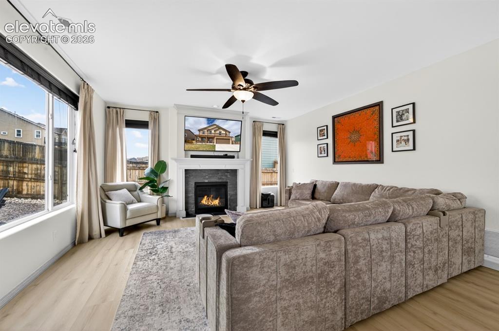 Image 22 of 50: Gas fireplace, large windows, ceiling fan, luxury vinyl, surround sound spe
