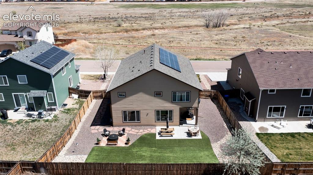 Image 45 of 50: Backyard, astroturf, covered patio, firepit, flagstone walkway, storage she