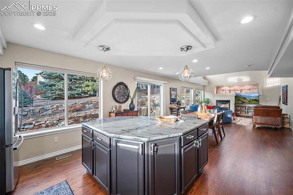 Image 14 of 50: Kitchen featuring granite counters, decorative light fixtures, stainless st