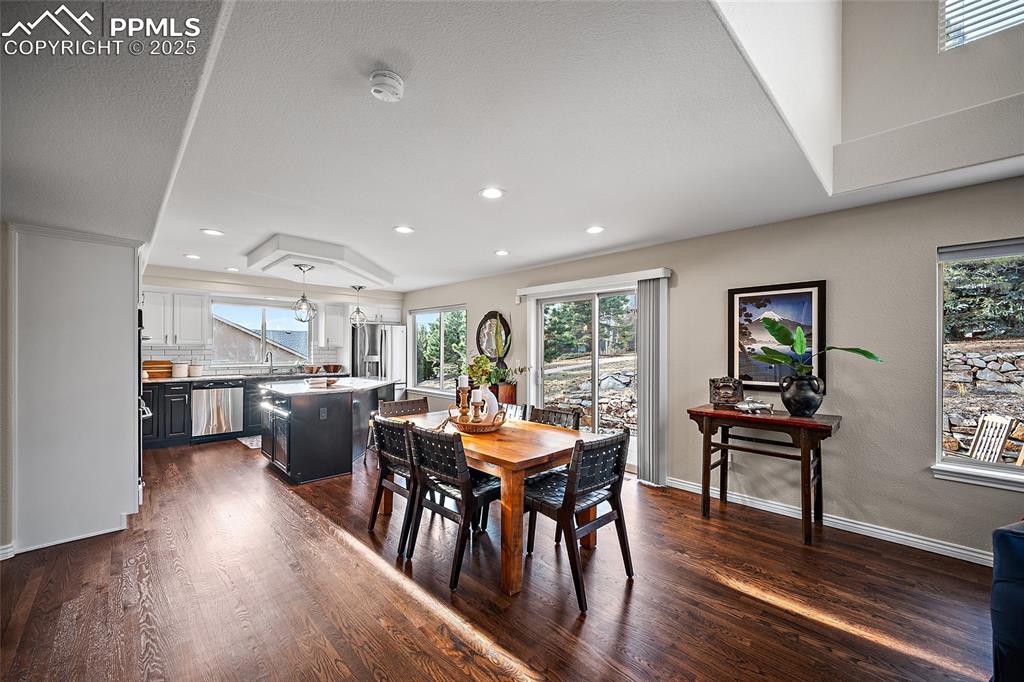 Image 15 of 50: Dining room with dark natural wood flooring and recessed lighting.