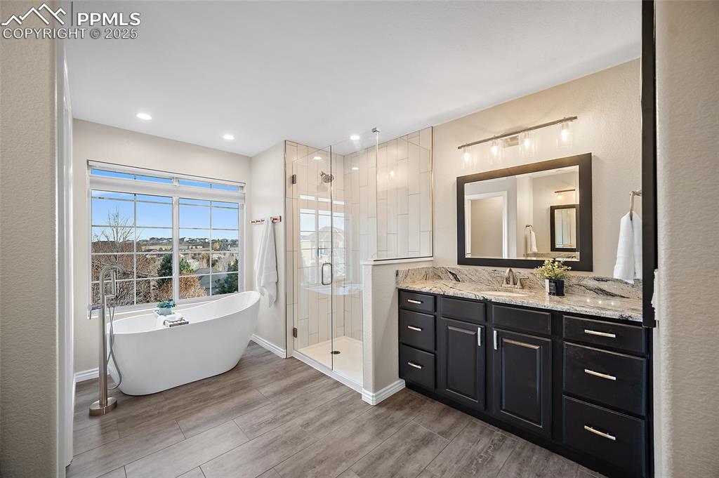Image 27 of 50: Fully remodeled primary bathroom with granite countertops, a freestanding t