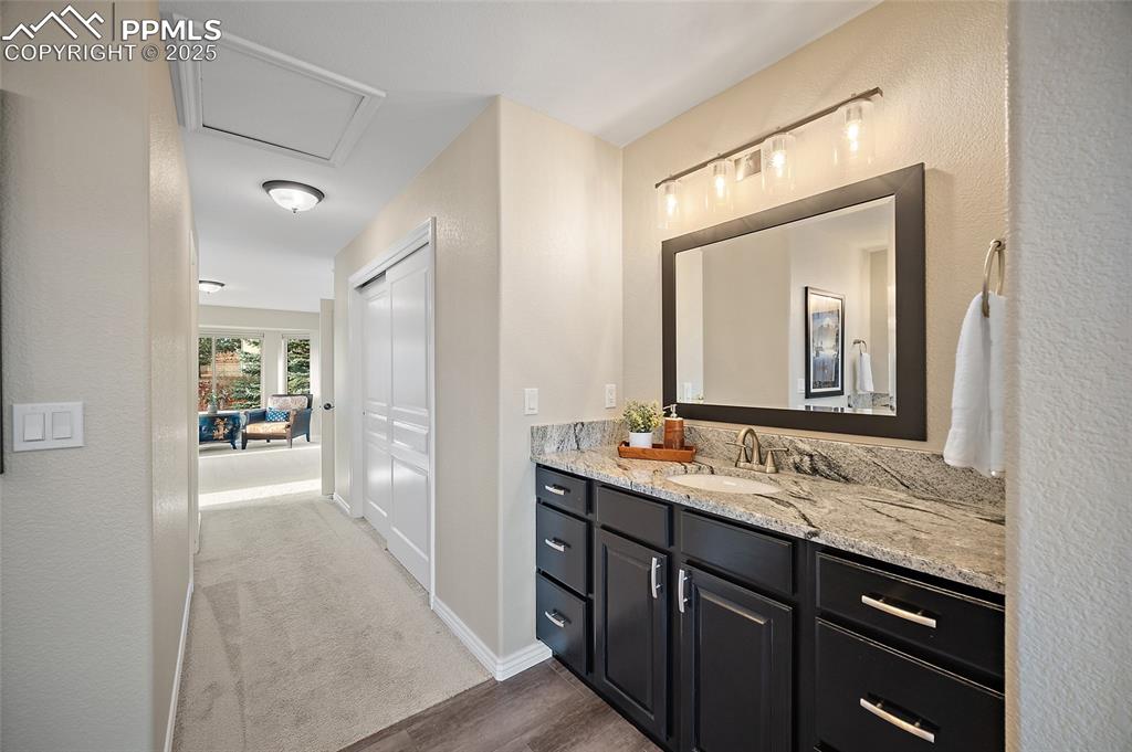 Image 28 of 50: Second vanity with granite countertops in primary suite.