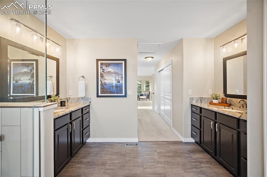 Image 29 of 50: Full bath featuring two vanities and wood finish floors