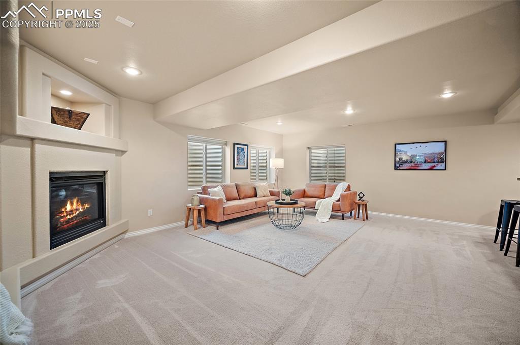 Image 37 of 50: Carpeted living area with recessed lighting and a fireplace
