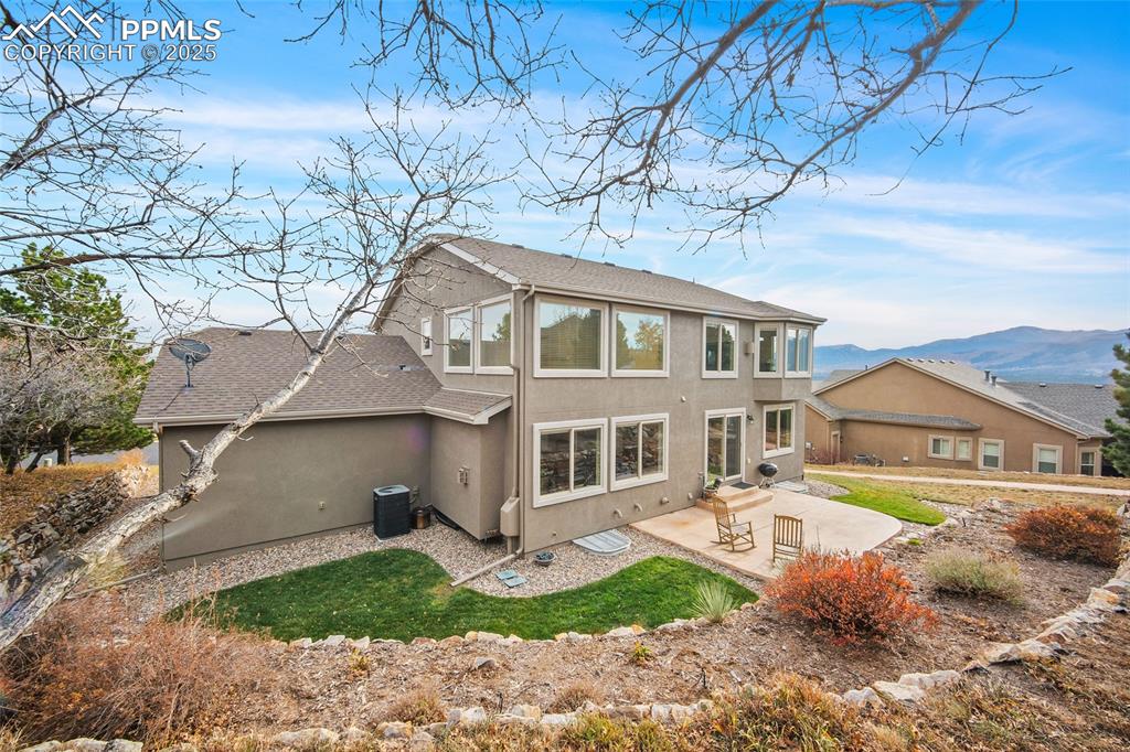 Image 42 of 50: Back of house with roof with shingles, a patio area, stucco siding, and a m