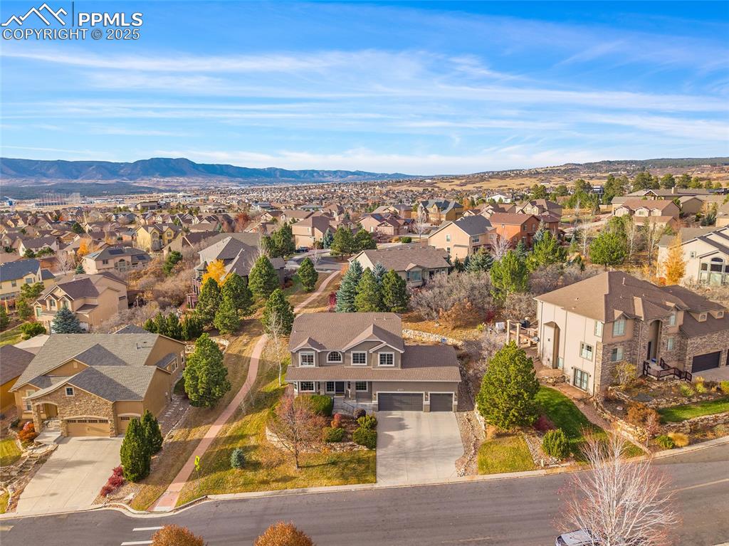 Image 46 of 50: Aerial view of residential area with mountains and walking path.