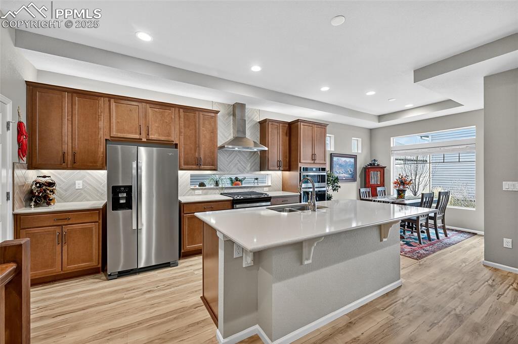 Image 15 of 43: Kitchen featuring appliances with stainless steel finishes, decorative back