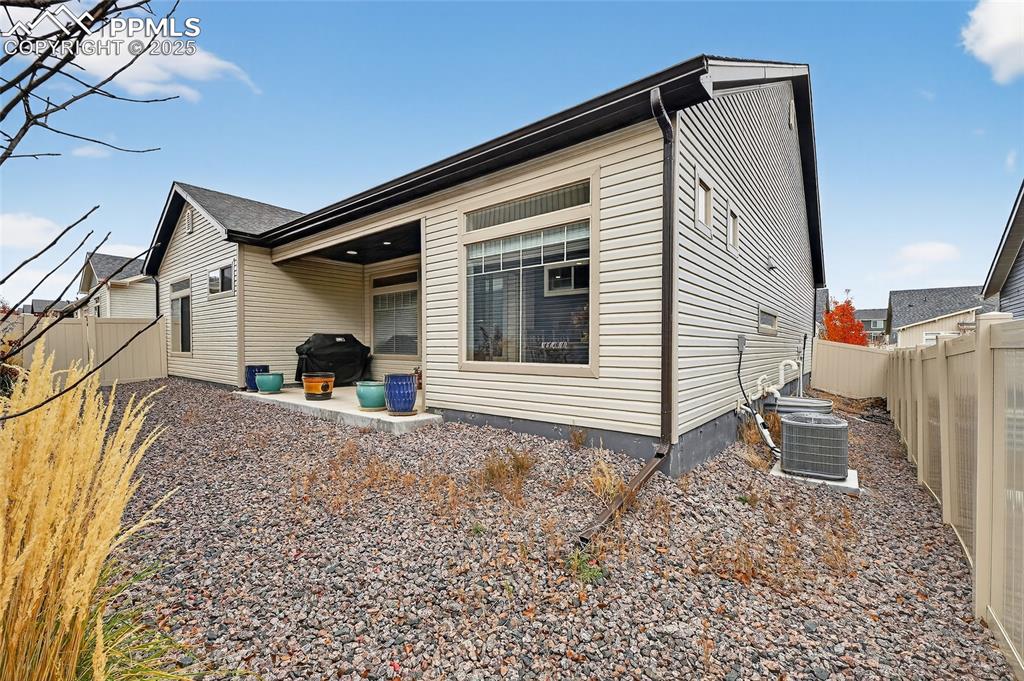 Image 24 of 43: Back of house featuring a fenced backyard and a patio area
