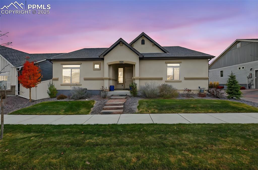 Image 5 of 43: View of front of home with a yard, stucco siding, and a shingled roof