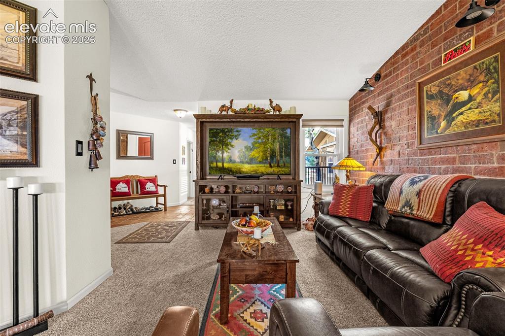 Image 5 of 21: Living room with brick accent wall -