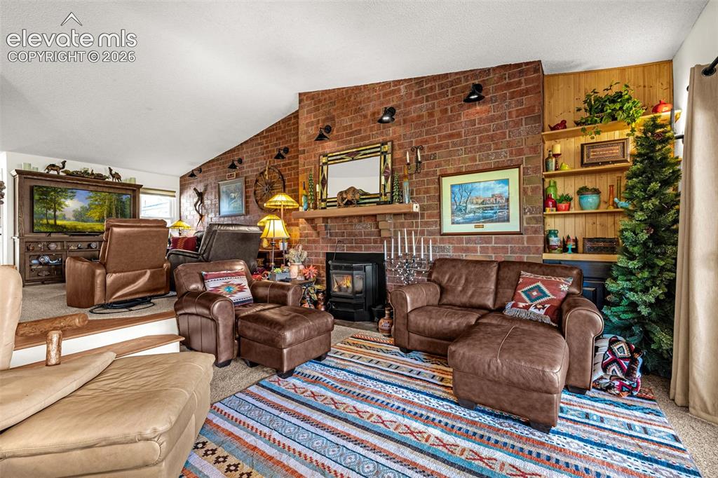 Image 8 of 21: Vaulted ceilings and a cozy pellet stove welcome you to the sunken family r